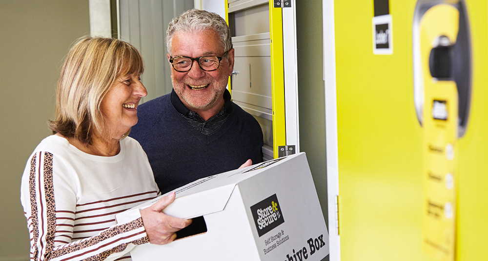 Middle aged couple placing personal items in a Store & Secure personal storage unit