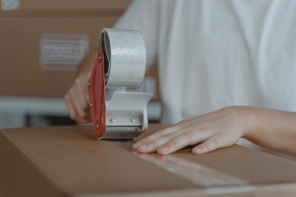 Person taping up a box.